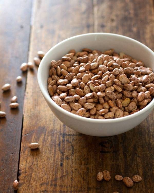 Pinto beans in a white bowl.