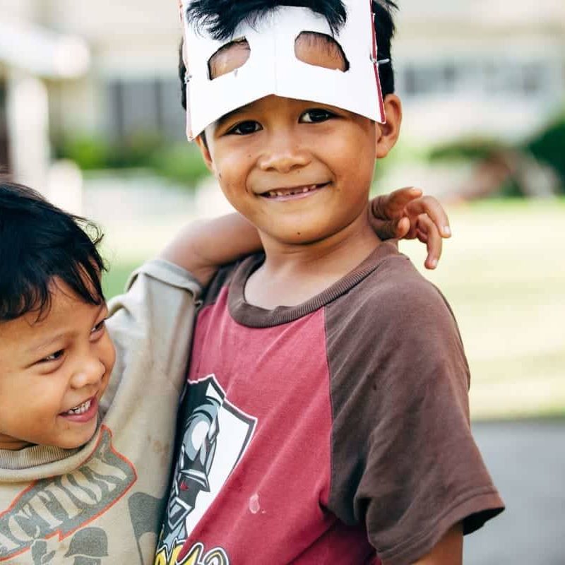 Two young boys playing with masks.