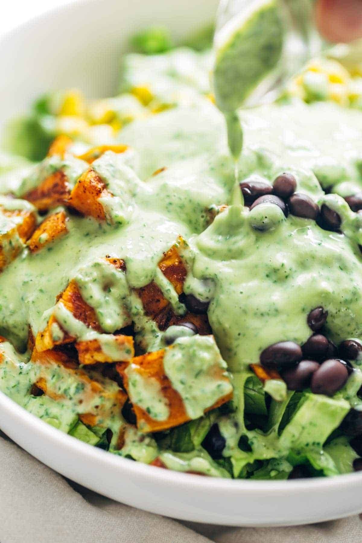 Avocado cilantro dressing poured on a salad.